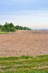 Fototapeta na wymiar Freshly Plowed Field In Spring Ready For Cultivation. Spring landscape in the countryside with fields against the sky. Agriculture and farming