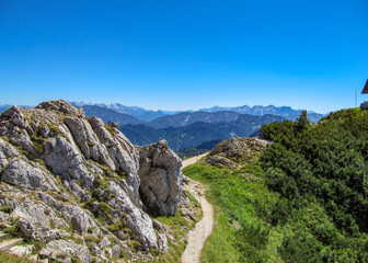 Panorama Aussicht vom bayrischen Berg Hochfelln auf den Chiemsee mit Gipfel Kreuz