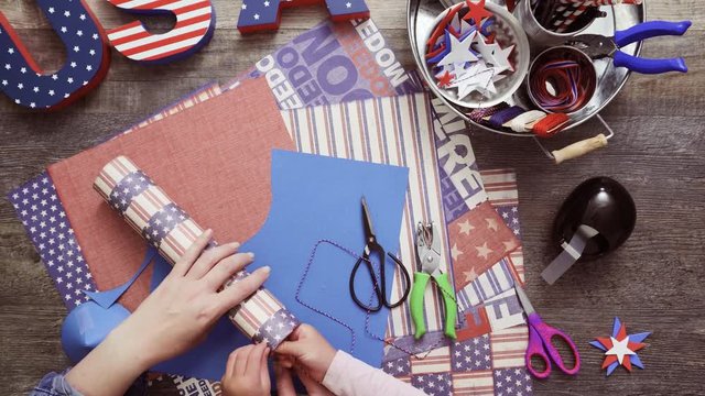 Step by step. Mother and daughter making paper firecrackers for July 4th celebration