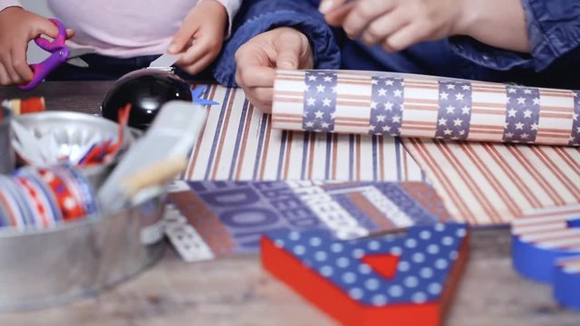 Time lapse. Step by step. Mother and daughter making paper firecrackers for July 4th celebration
