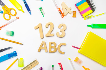 letters A, B, C. numbers 1, 2, 3 on the school desk. concept of education. back to school. stationery. White background. stickers, colored pens, pencils, scissors. view from above. flat lay.