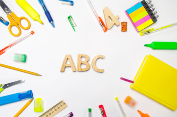 letters A, B, C on the school desk. concept of education. back to school. stationery. White background. stickers, colored pens, pencils, scissors. view from above. flat lay.