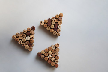 Three wine corks triangles arranged in triangular shape on white background with copy space