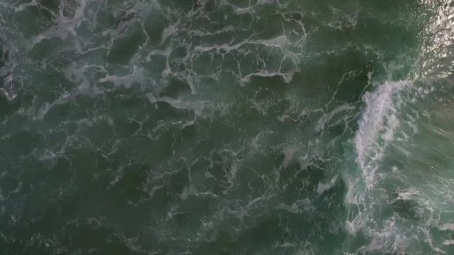 Aerial shot of some waves moving along the beach in Ballybunion, Ireland.