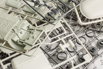 kit for assembling gray plastic car model on white background