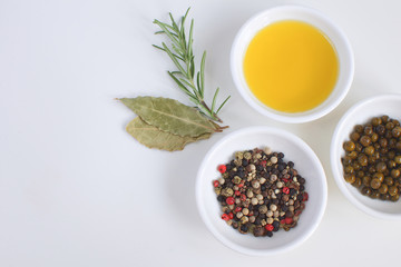 Olive oil porcelain plate Rosemary branch Pepper mix Bay leaf Cooking concept White background Top view Copy space Flat lay