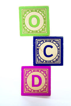 Wooden letter blocks on a blue background spelling out the initials OCD