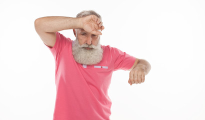 Old man looking worried with hand on forehead.