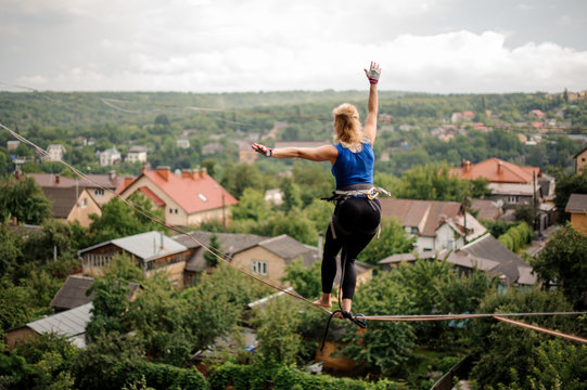 Rear view woman walking on the slackline rope