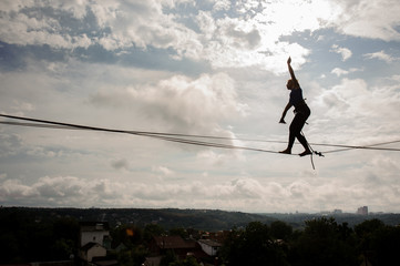 Young active woman walking on the slackline rope