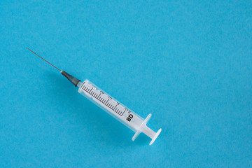 Syringe isolated on blue background. Medicine