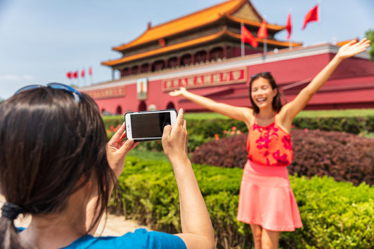China travel tourists taking picture with photo at Forbidden City in Beijing, China. Asia trip summer vacation. Two Asian women having fun taking photos at famous chinese landmark.