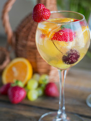 Homemade refreshing fruit sangria or punch with champagne, strawberries, oranges and grapes.