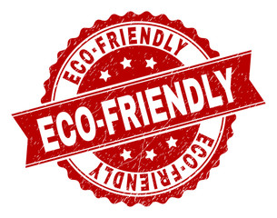 ECO-FRIENDLY seal print with corroded texture. Rubber seal imitation has round medal form and contains ribbon. Red vector rubber print of ECO-FRIENDLY caption with scratched texture.