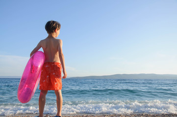 Boy with inflatable ring on seashore