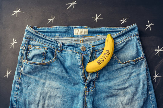 Banana with inscription "nofap" out of jeans like mens penis. Concept sexual problems.
