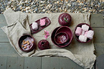 Set of handmade ceramics in purple on a piece of gray burlap. Rustic style. Clay modeling