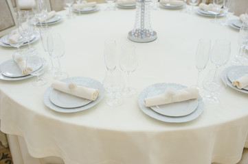 The banquet hall with round tables, with cutlery