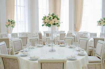 The banquet hall with round tables, with cutlery