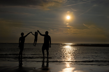Fototapeta premium young family at the sun set on the Katwijk beach, Netherlands
