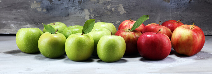 Ripe red apples with leaves on wooden background.