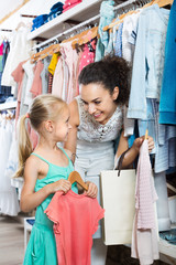 Woman with small girl choosing pink clothes