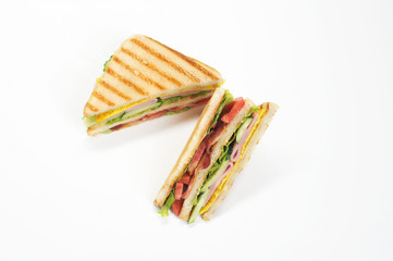 Classic club sandwich. The filling of the sandwich consists of ham, bacon, cheese and fresh vegetables. White background. Close-up. 