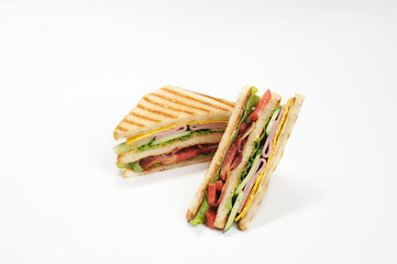 Classic club sandwich. The filling of the sandwich consists of ham, bacon, cheese and fresh vegetables. White background. Close-up. 