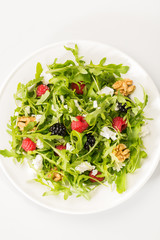 Salad with berry, nuts, goat cheese, olive oil.