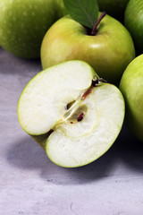 Ripe red apples with leaves on wooden background.