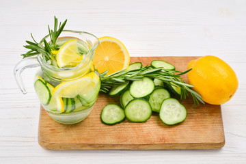 Cold and refreshing detox water with lemon, cucumber, rosemary and ice in glass jar. Copyspace. Banner
