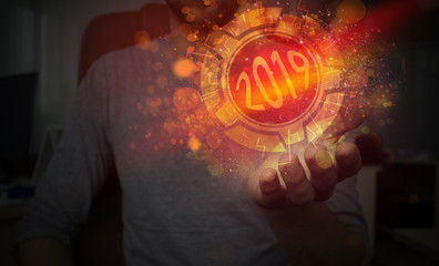 A magic ball in the hand of 2019. The abstract New Year's background, neon, dark bokeh. Holography 2019