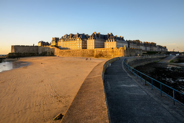 View at sunset of the walled old city of Saint-Malo in Brittany, France, with granite buildings...