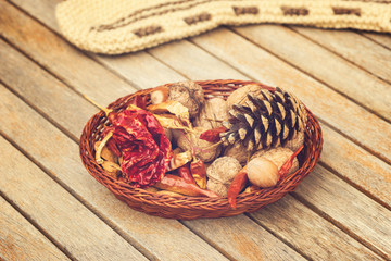Red chili peppers, walnuts, chestnut and conch in a wooden bowl on an old wooden background.