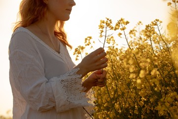 Woman touching crops in the mustard field