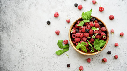Fresh raspberries in  bowl on  gray background. Top view
