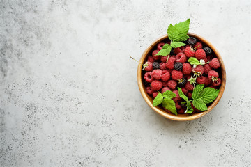 Fresh raspberries in  bowl on  gray background. Top view
