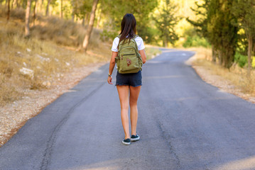 Woman hiker with backpack walking alone on roads in the forest ,concept of journey travel or sport background.