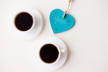 two cups of coffee on the table that says home.