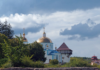 Fototapeta na wymiar Orthodox Church and restored tower of ancient fortress in medieval village Busha, Vinnytsia Oblast, Ukraine.