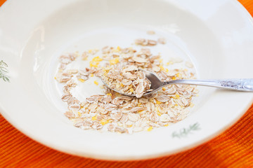 oatmeal in white bowl on orange napkin.