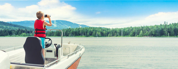 The child dreams of becoming a captain. The first swimming on a motor boat on the lake.