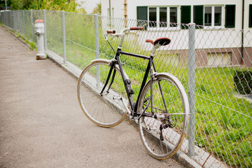 Fototapeta premium Black bike leaning on fencei in the city