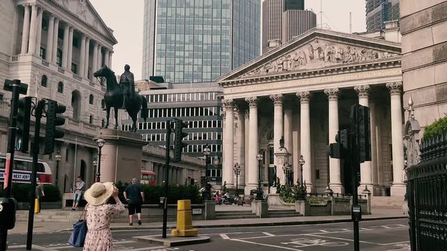 A lady taking photo of Royal Exchange and Bank of England