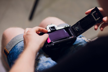 man installing photo film cartridge in film camera