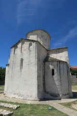 Fototapeta na wymiar Eastern wall of Church Of Holy Cross in Nin town, Croatia, Adriatic. Known as smaller cathedral, this church is most notable religious landmark in Nin
