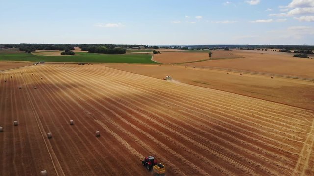 Aerial view of tractor harvesting crop in a field in Sweden
