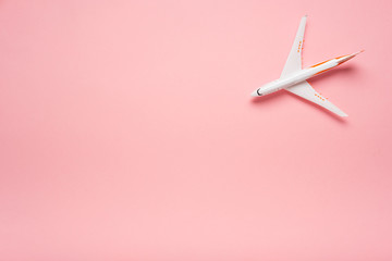 Top view of an airplane on trendy pink background.  Bright summer color. Travel concept.