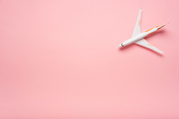 Top view of an airplane on trendy pink background.  Bright summer color. Travel concept.