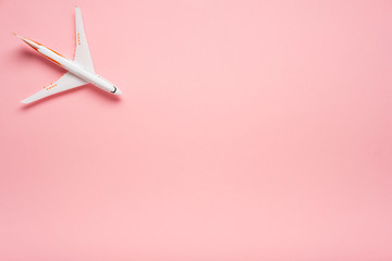 Top view of an airplane on trendy pink background.  Bright summer color. Travel concept.